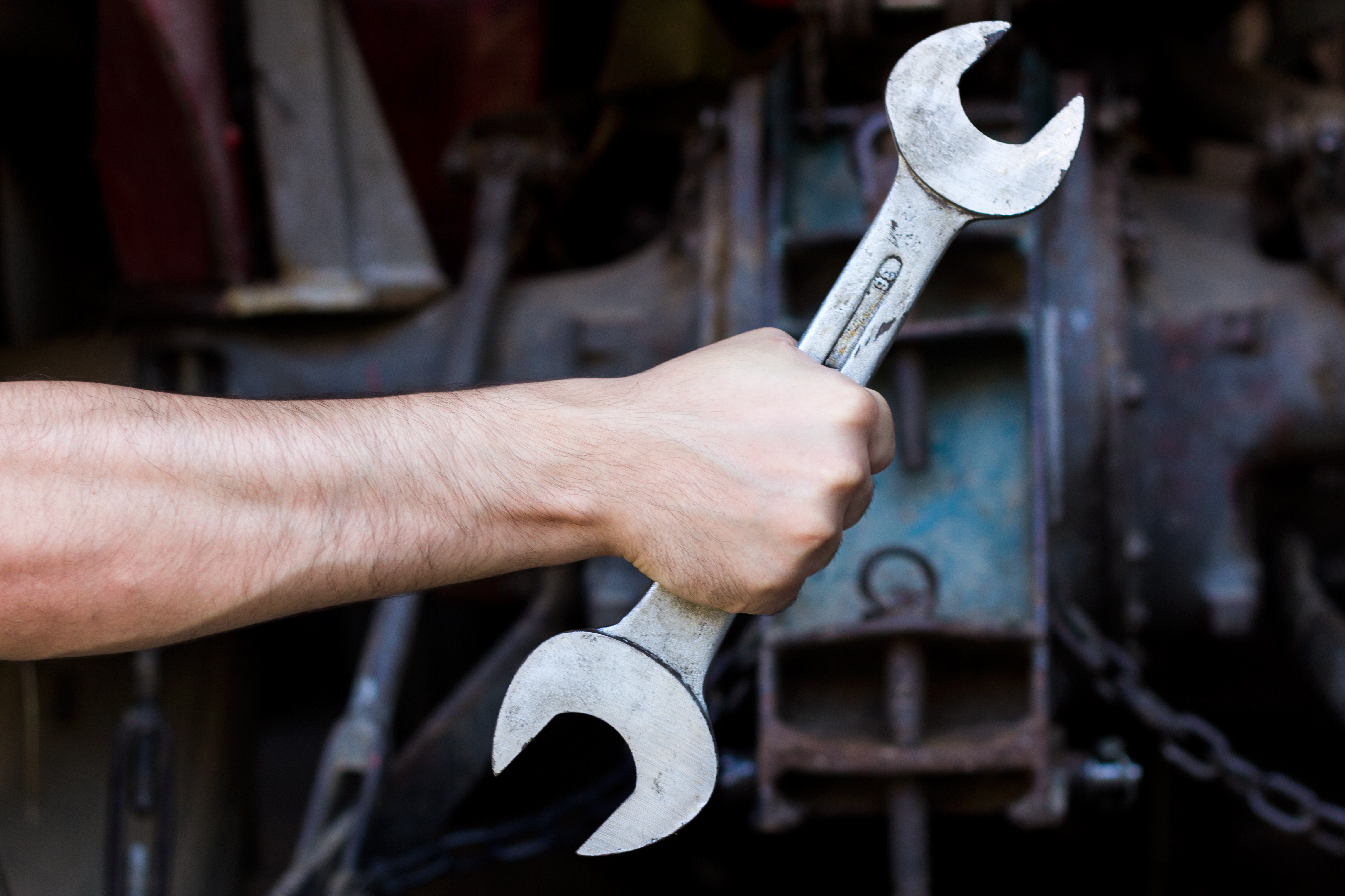 hand-holding-wrench-dark-background